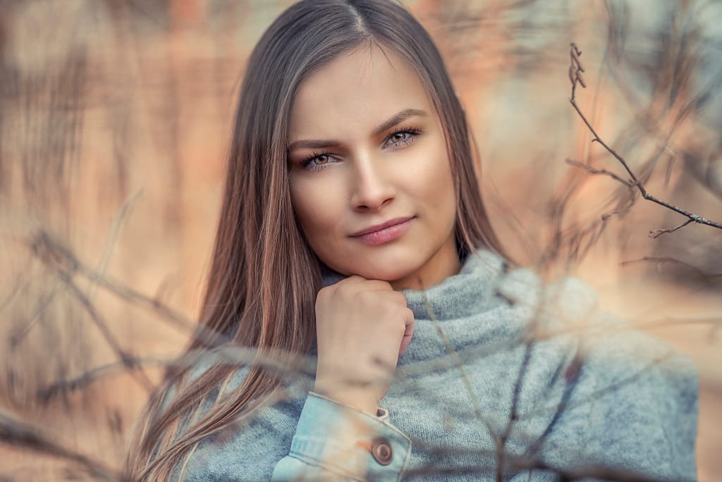 Jak przygotować się do portretowej sesji zdjęciowej w studiu i w plenerze? Kompleksowy przewodnik od fotografa 3 Portret kobiety w jesiennej scenerii – fotografia plenerowa w ciepłych barwach fotograf Lublin, klimatyczna sesja plenerowa