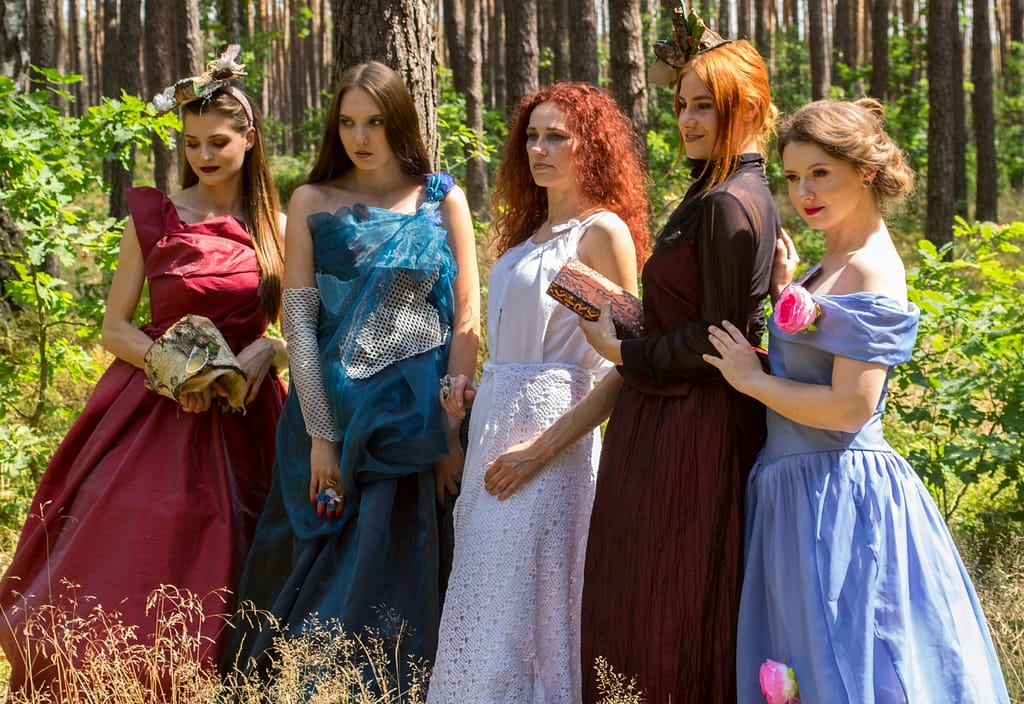 Sesja Bajkowo-Baśniowa w lesie – gdy fotografia spotyka magię 3 Pięć modelek w kolorowych sukniach podczas artystycznej sesji zdjęciowej w lesie