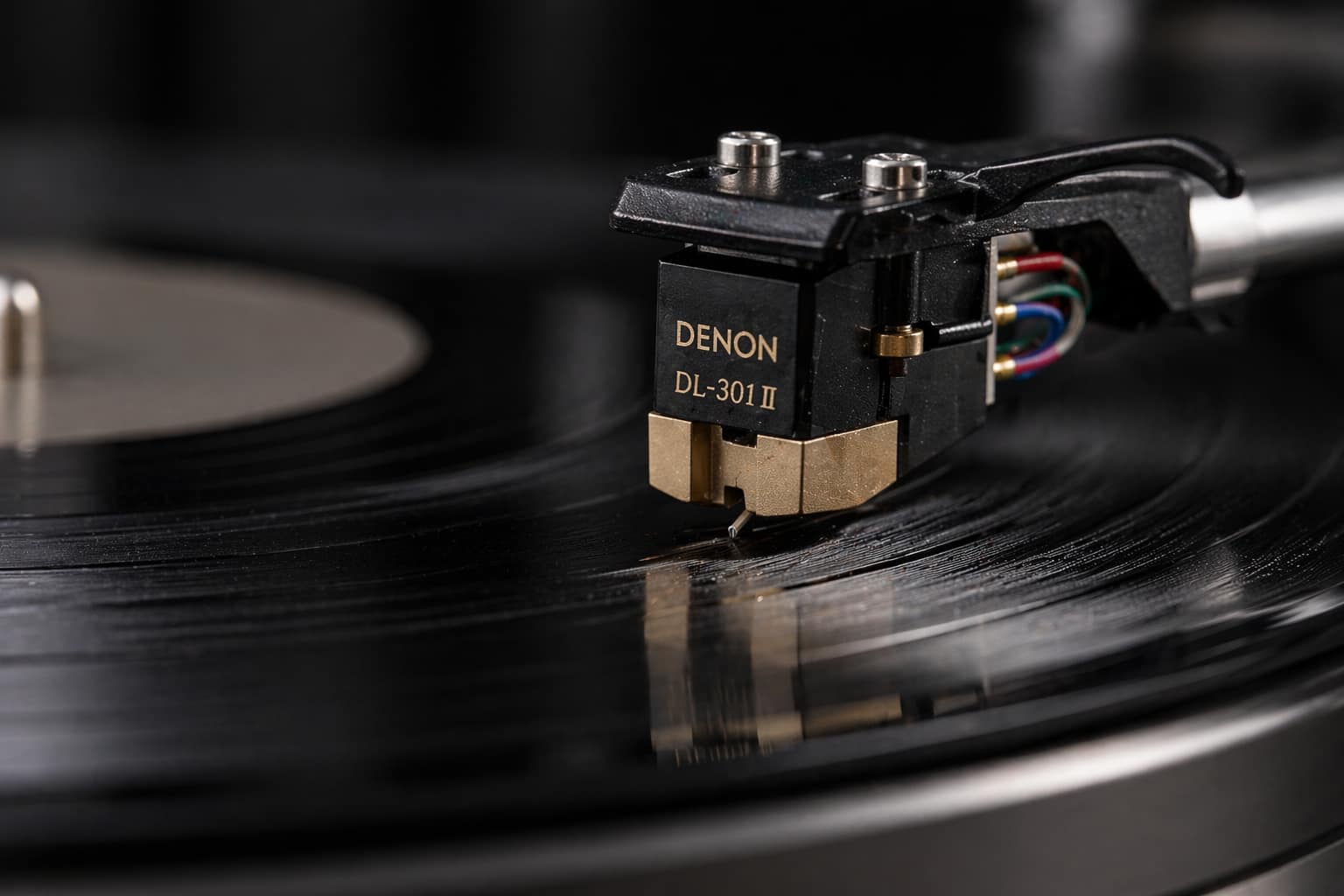 Dlaczego winyl trzeszczy? Przyczyny i jak to naprawić 4 Wkładka Denon DL-301 II zamontowana na ramieniu gramofonu podczas odtwarzania płyty winylowej