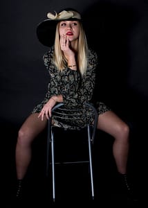 Fashion editorial – kobieca stylizowana sesja zdjęciowa w studio Kobieta w kapeluszu siedząca na krześle, modowa sesja zdjęciowa studio, styl fashion editorial