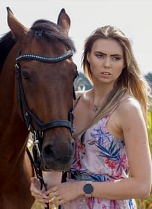 Fotografia plenerowa Lublin – sesja kobieca z koniem portret kobiety stojącej obok konia w plenerze