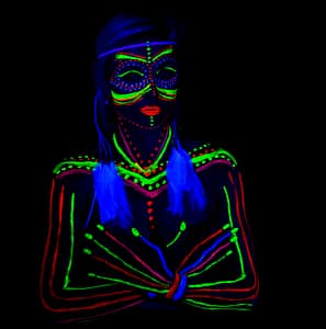 portret modelki w świetle UV z makijażem fluorescencyjnym i piórami