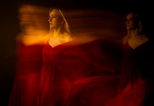 Artystyczna fotografia w czerwonej sukni z efektem ruchu, sesja kreatywna studio