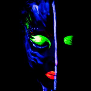 Kreatywny portret w świetle UV z fluorescencyjnym makijażem, kontrastowe kolory zieleni i czerwieni na czarnym tle tworzą futurystyczny klimat fotografii artystycznej