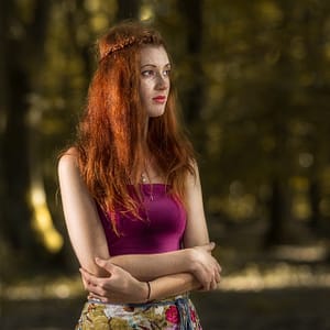Portret rudowłosej w lesie Portret kobiety z rudymi włosami i piegami w naturalnym świetle lasu, fotografia plenerowa beauty, artystyczna sesja portretowa z klimatem jesiennego światła