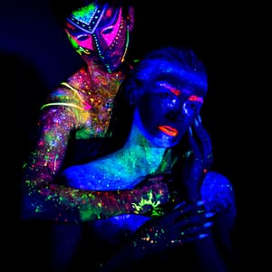 Artystyczny portret UV z neonowym bodypaintingiem i fluorescencyjnymi kolorami, fotografia kreatywna w świetle ultrafioletowym, styl fantasy i glow, intensywne barwy oraz kontrastowe światło studyjne
