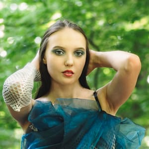 Beauty portrait w zieleni Artystyczny portret kobiety w zielonej stylizacji z delikatnym makijażem i miękkim światłem naturalnym, fotografia beauty w plenerze z rozmytym tłem liści i subtelną atmosferą sesji modowej