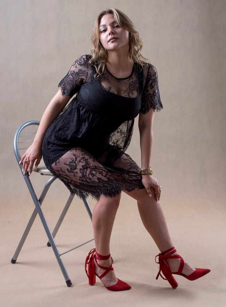 Sesja sensualna Lublin – jak wygląda, ile kosztuje i czy jest dla Ciebie? 3 kobieta siedząca na krześle w czarnej koronkowej sukni i czerwonych szpilkach